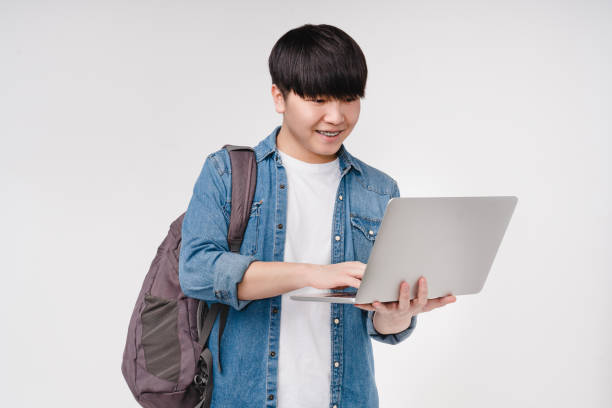 istock Smart smiling young asian korean student schoolboy using laptop, e-learning remotely at university college, browsing projects online isolated in white background 1371132177