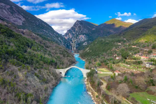 Photo of The great arched stone bridge of Plaka on Arachthos river, Tzoumerka, Greece.