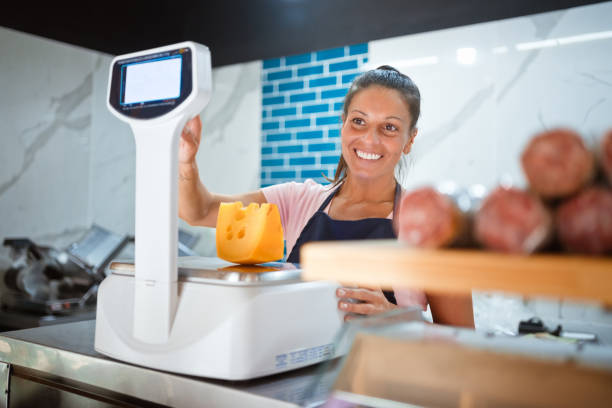istock Smiling female owner weighing cheese at checkout 1371134818