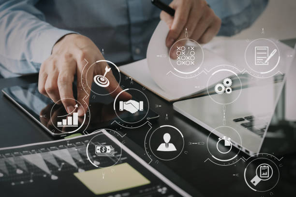 close up of businessman working with smart phone and digital tablet and laptop computer  on wooden desk in modern office with glass reflected view stock photo