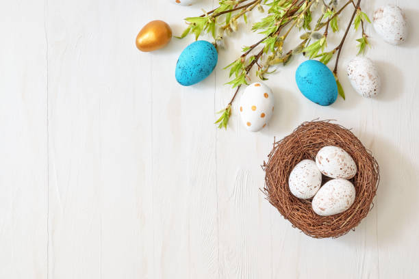 istock Branches with green leaves and easter eggs on a light background. Happy easter flat lay concept 1371137500