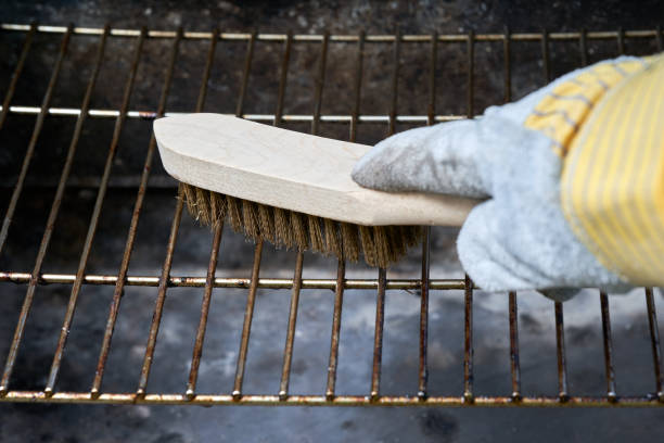 Wooden wire brush cleans dirty barbecue grill rust. Leather protection gloves. Wooden wire brush cleans dirty barbecue grill rust. Leather protection gloves. metal grate stock pictures, royalty-free photos & images