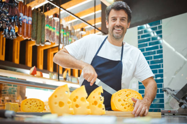 istock Smiling owner cutting cheese on kitchen counter 1371137741
