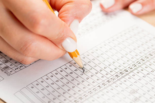 istock Female hand holds pencil and marks answers to test. Hiring Testing Concept 1371139057