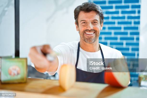 Smiling Salesman Holding Knife By Cheese Slices Stock Photo - Download Image Now - Adult, Adults Only, Business