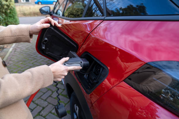 istock Young woman charging electric car 1371142465