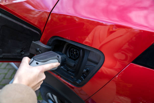 istock Young woman charging electric car 1371142569