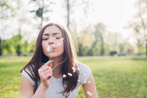 istock Girl Blowing A Dandelion In The Park 1371143107