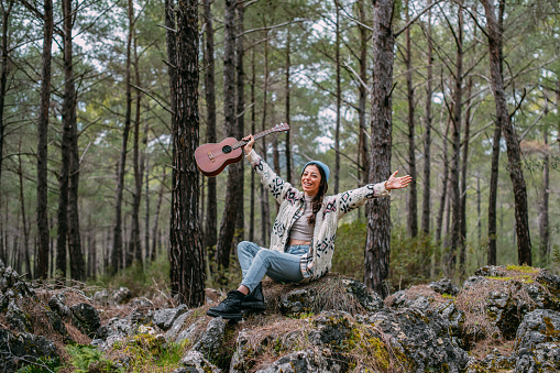 Young Woman With Her Guitar in the Forest