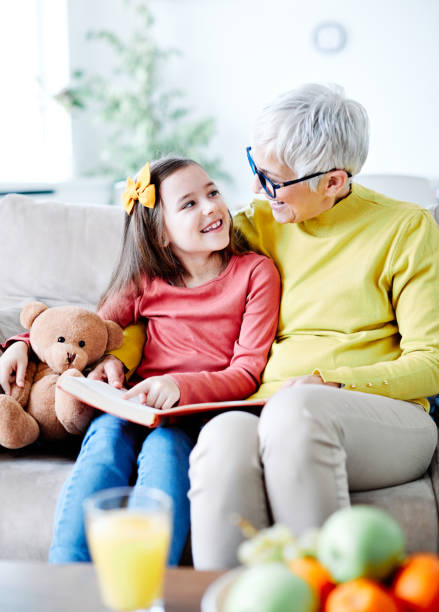 grandchild granddaughter grandma grandmother reading book girl senior - grandparent reading grandmother child imagens e fotografias de stock