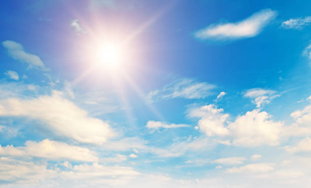 Blue sky, sun and Cumulus clouds.