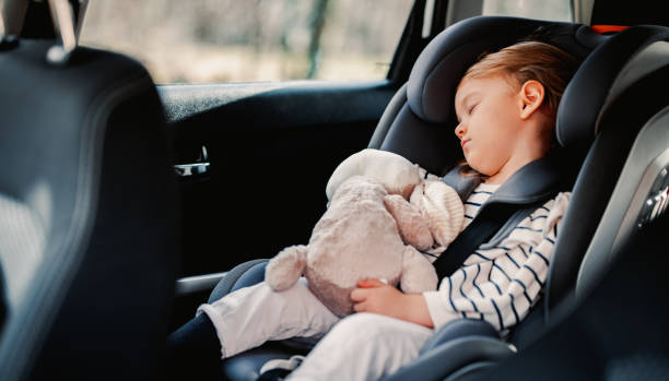 Little Girl Sleeping While Traveling by Car Cute girl napping with her toy in child safety seat in the car. seat belt photos stock pictures, royalty-free photos & images