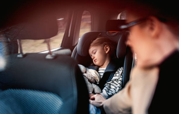 niña durmiendo mientras viaja en coche con su madre - baby mother sleeping child fotografías e imágenes de stock