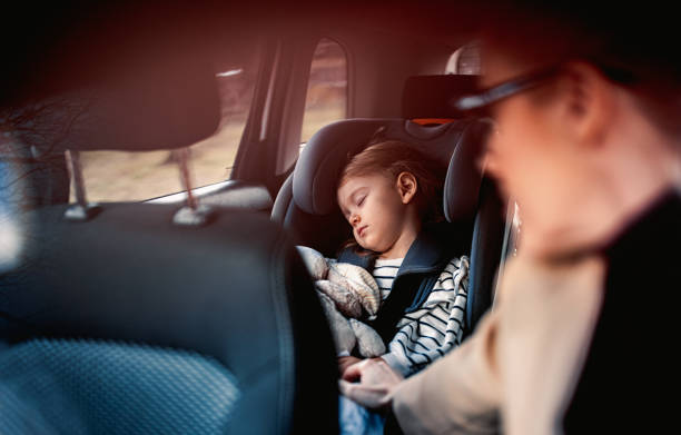 little girl sleeping while traveling by car with her mother - car baby baby car seat child imagens e fotografias de stock