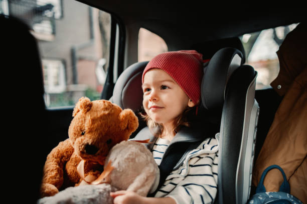 Little Girl Holding her Favorite Toy While Traveling by Car stock photo