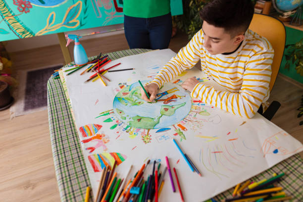 istock Creative schoolboy drawing the art about environment 1371150183