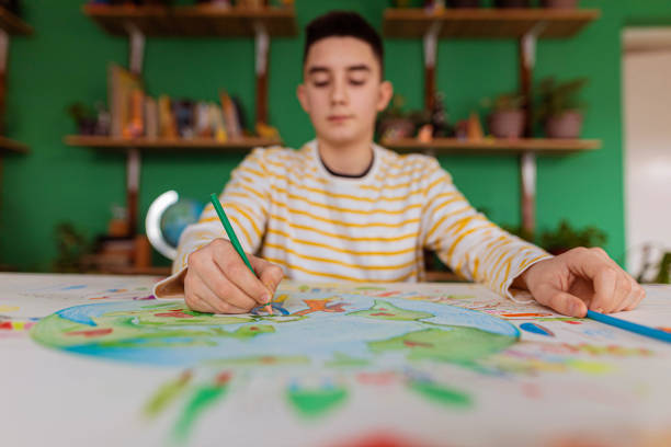 Portrait of creative Caucasian schoolboy, drawing the art about environment and sustainability