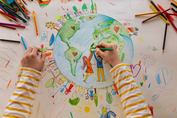 認識できない少年の高い角度のビューは、人々と惑星地球を描きます - 宿題 ストックフォトと画像