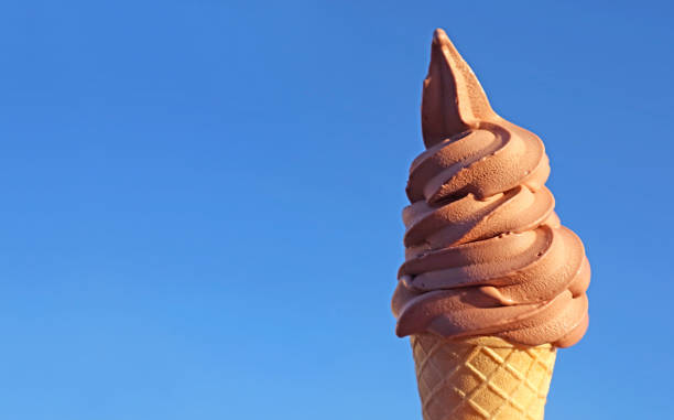 istock Chocolate Soft Serve Ice Cream Cone Against Vibrant Blue Sunny Sky 1371150659