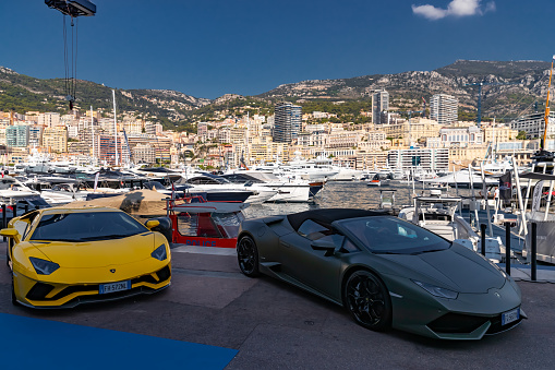 Monaco, Monte-Carlo, 27 September 2019: Two luxury sport cars Lamborghini of dark color are in port Hercules in shadow, very aggressive view of roadster, cabriolet, a lot of yachts are on background. High quality photo