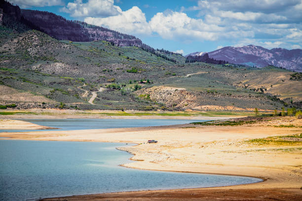 Almost dried up Blue Mesa Reservoir near Gunnison Colorado USA with pickup parked down near water and someone floating stock photo