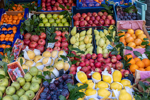 greengrocer's stall with lots of fresh products for sale in the fruit market with prices