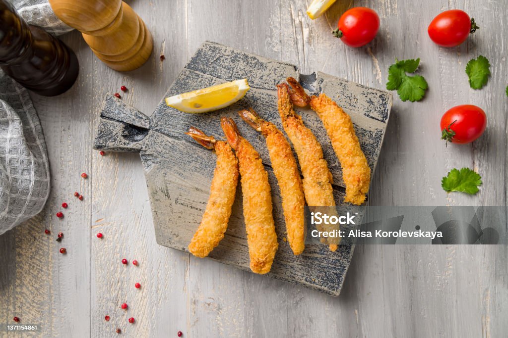 fried tempura shrimps with lemon on wooden board top view Fried Stock Photo