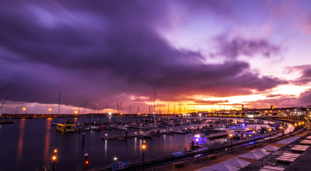 Sunset and clouds, marina with boats, vivid colors, Ponta Delgada, Azores. stock photo
