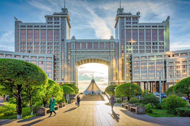 Pedestrians walk in downtown Nur-Sultan Kazakhstan at sunset time.