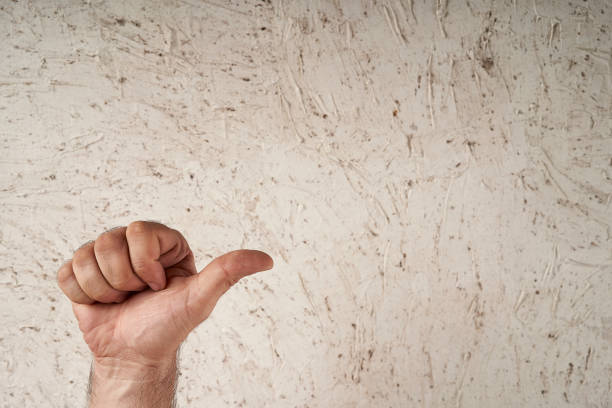 man hand pointing thumb to the right or up vertically