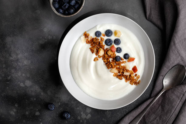 istock Blueberries in white yogurt with granola in white bowl on grey background. Top view. Breakfast idea. 1371159355