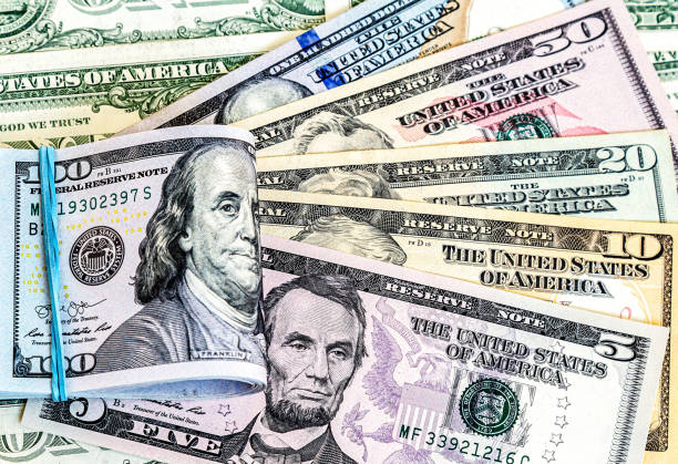 istock Folded american dollars banknotes wrapped by rubber band over dollars banknotes 1371160118