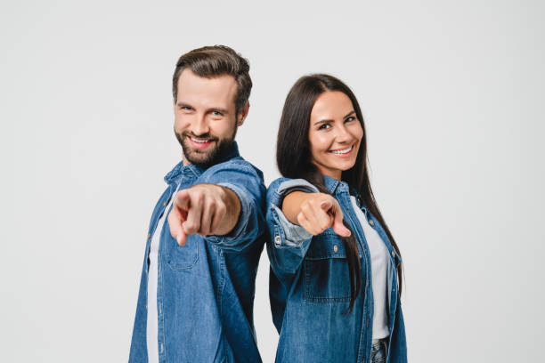 casal de jovens cônjuges caucasianos apontando para a câmera, escolhendo você para novas oportunidades, desafio, selecionando vencedor isolado em fundo branco - women customer service representative people sales occupation - fotografias e filmes do acervo