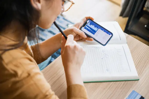 Photo of Businesswoman analyzing financial stock market on smartphone