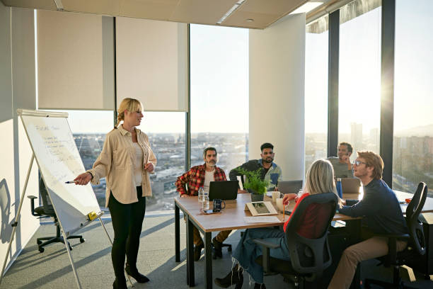 istock Project manager discussing plans with team in modern office 1371160728