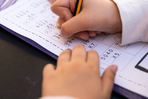 istock Close up on little girl hands doing school homework 1371161605