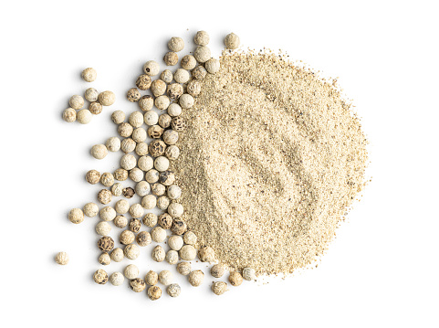 White ground pepper and whole peppercorn spice isolated on a white background.