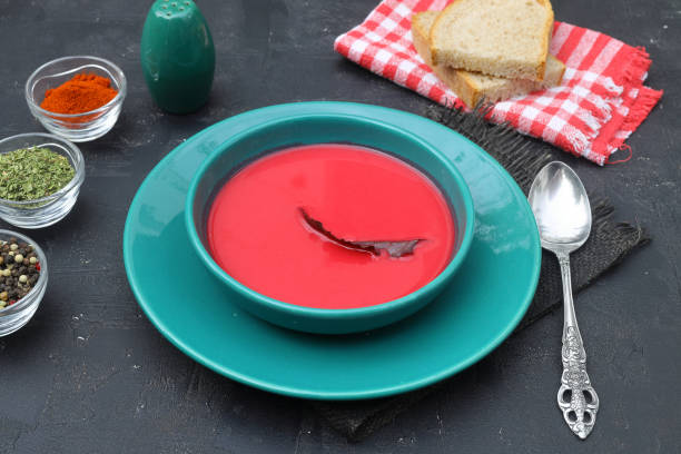 Hot rich fresh borscht, beet soup. Plate of red beetroot soup borscht on black rustic table. Beetroot soup, top view