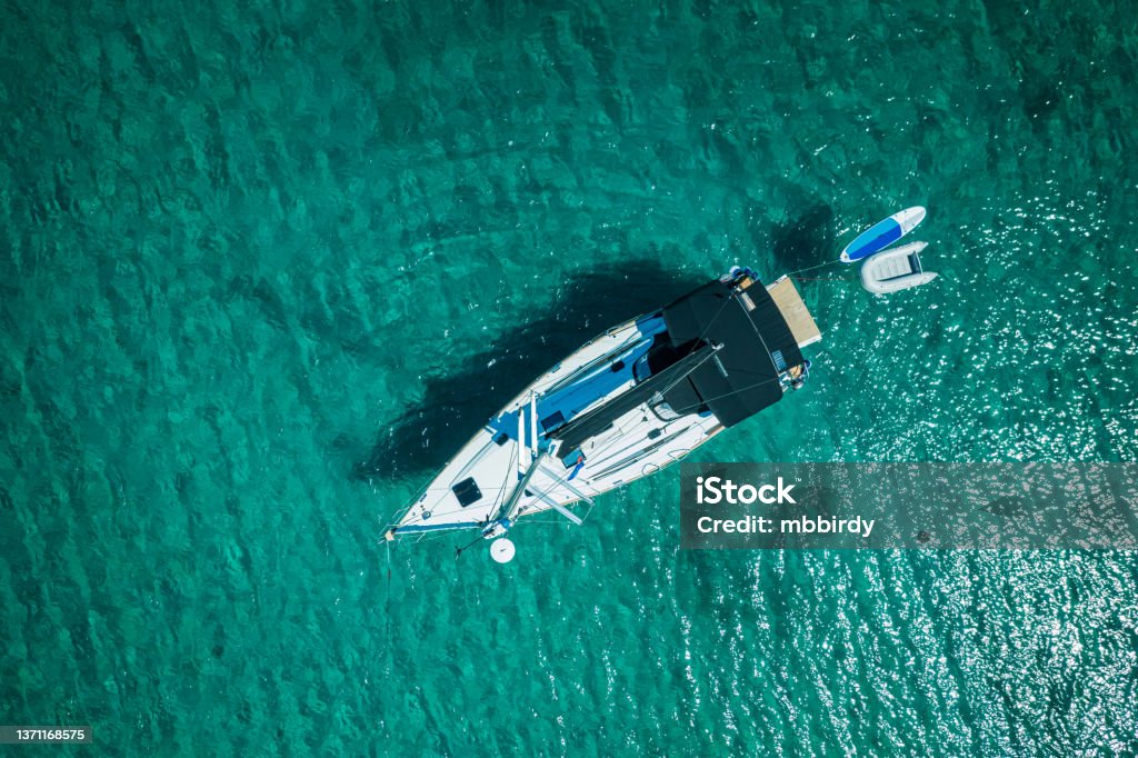 Anchored sailboat, view from drone Anchored sailboat at Olib island, Croatia. High angle view from drone. Sailboat Stock Photo