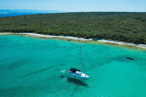 Anchored sailboat at Olib island, Croatia. High angle view from drone.