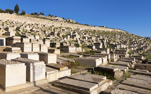 East Jerusalem, Palestine, May 3, 2019: View of the old Jewish cemetery under the Mount of Olives on a sunny spring afternoon.