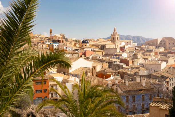 panorama del casco antiguo de relleu en la costa mediterránea en la provincia de alicante, españa, techos de tejas de la cúpula de la iglesia y hermosas palmeras - roof tile vacations urban scene outdoors fotografías e imágenes de stock