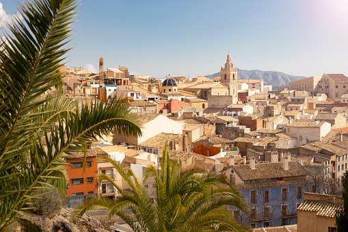 Panorama of the old town of Relleu on the Mediterranean coast in the province of Alicante, Spain, tiled roofs of the church dome and beautiful palms.
