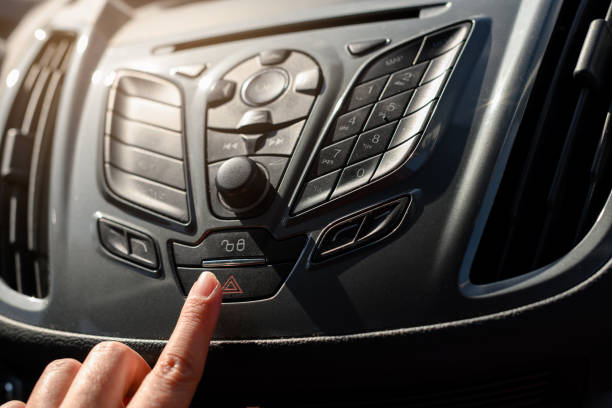 istock Finger on the red triangle button of a car's hazard warning lights panel 1371169789