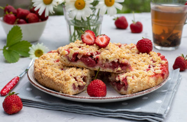 istock Italian sbricholata pie with shortcrust pastry and strawberries on a gray table with a bouquet of daisies. Still life in an open space 1371170880
