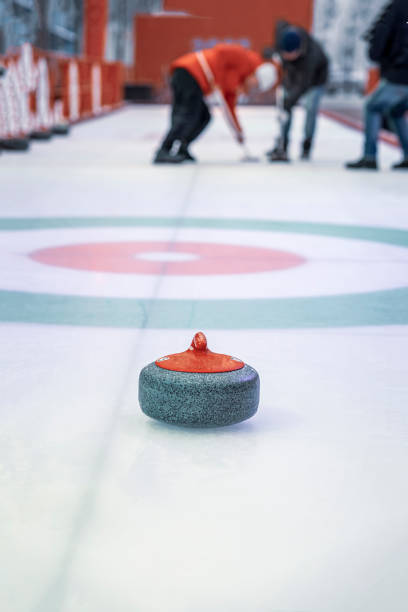 istock Granite projectile for curling on ice against background of playing athletes, selective focus 1371172265