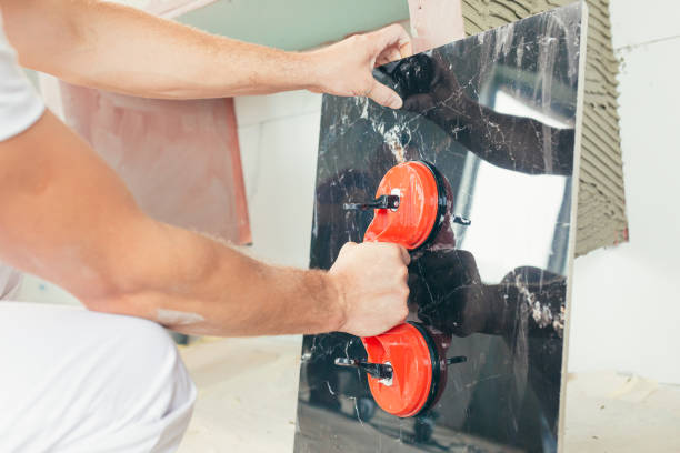 istock A male worker mounts a large ceramic tile in the bathroom 1371173622