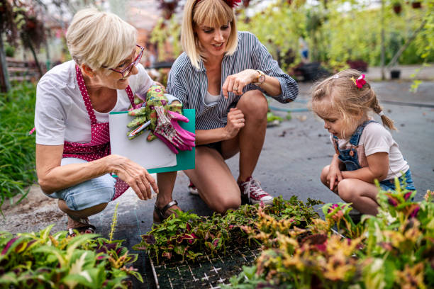 bambina che impara a conoscere il giardinaggio botanico da sua madre e sua nonna - casual granddaughter farmer expressing positivity foto e immagini stock