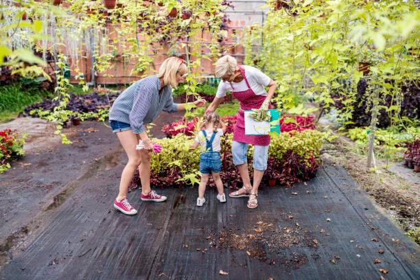 grand-mère, fille et petite-fille s’amusent ensemble dans une serre botanique - casual granddaughter farmer expressing positivity photos et images de collection