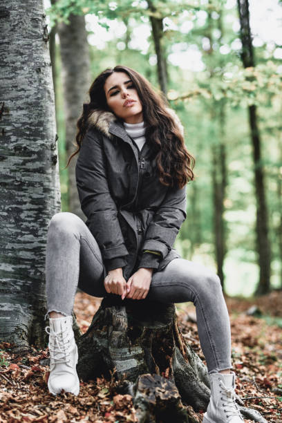 istock Long Haired Female Beauty Relaxing On Tree Stump In Forest 1371174633